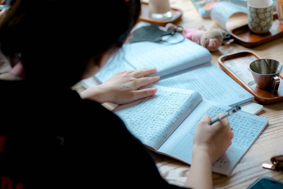 静かな環境で学習と教育に重点を置いて勉強し、ノートに書き込む人。