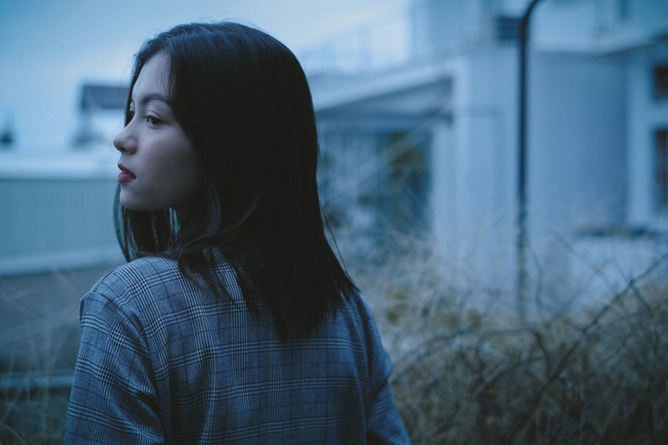 孤独の乾いた草の中に立っている夢のような女の子