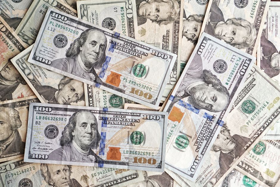 金融と経済を表す山に並べられたさまざまな額面の米ドル紙幣のクローズアップ。